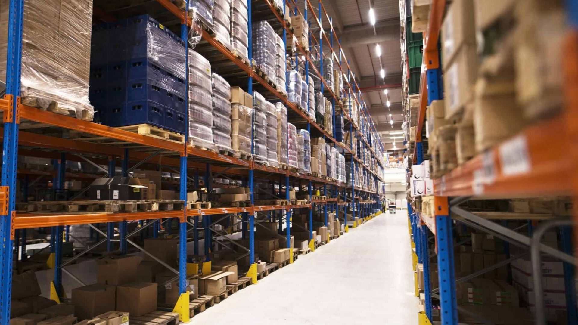 interior-large-distribution-warehouse-with-shelves-stacked-with-palettes-goods-ready-market-scaled